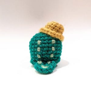 Green crochet amigurumi crocodile wearing a gold hat